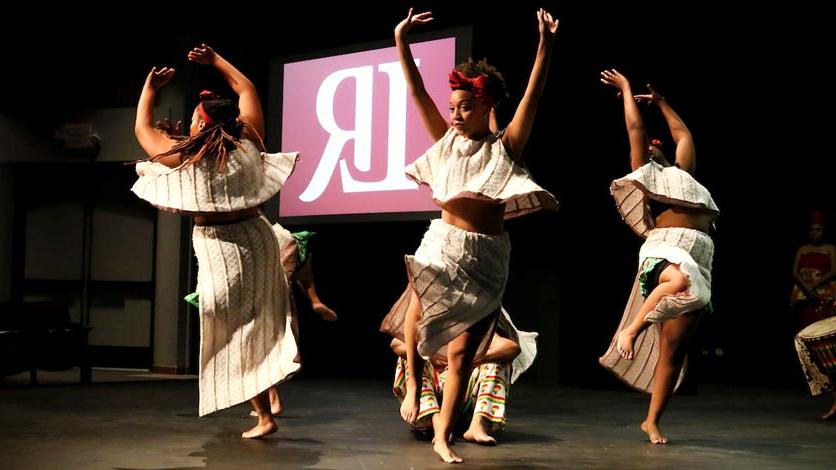 Students dancing on stage at event